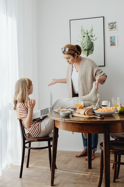 Free Mother Scolding Child for Bad Behavior at Table Stock Photo