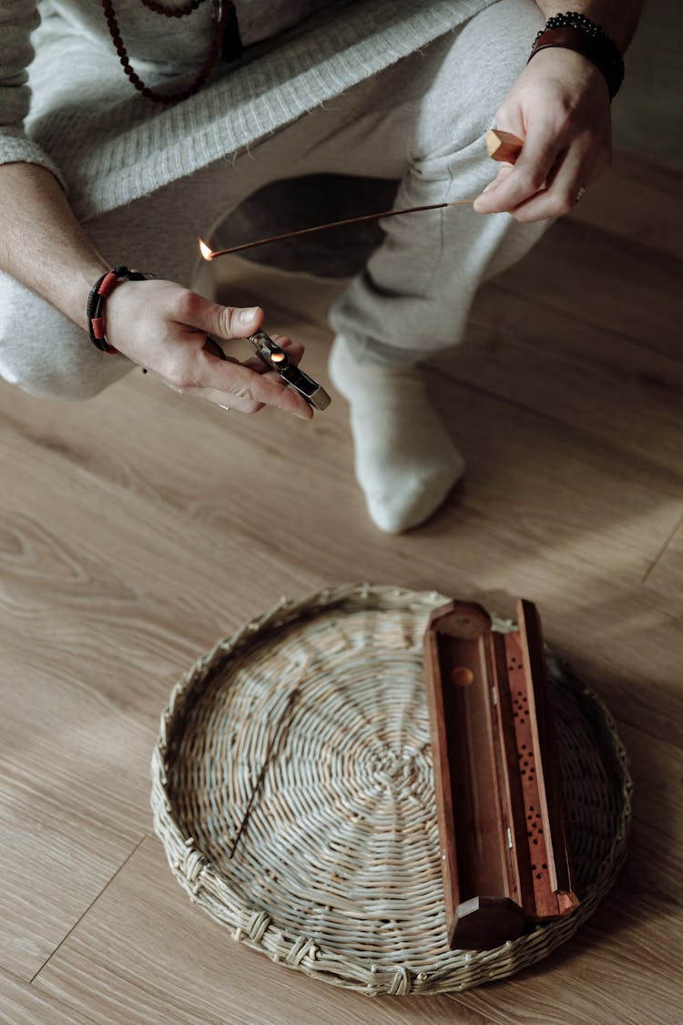 A Person Lighting An Incense Stick