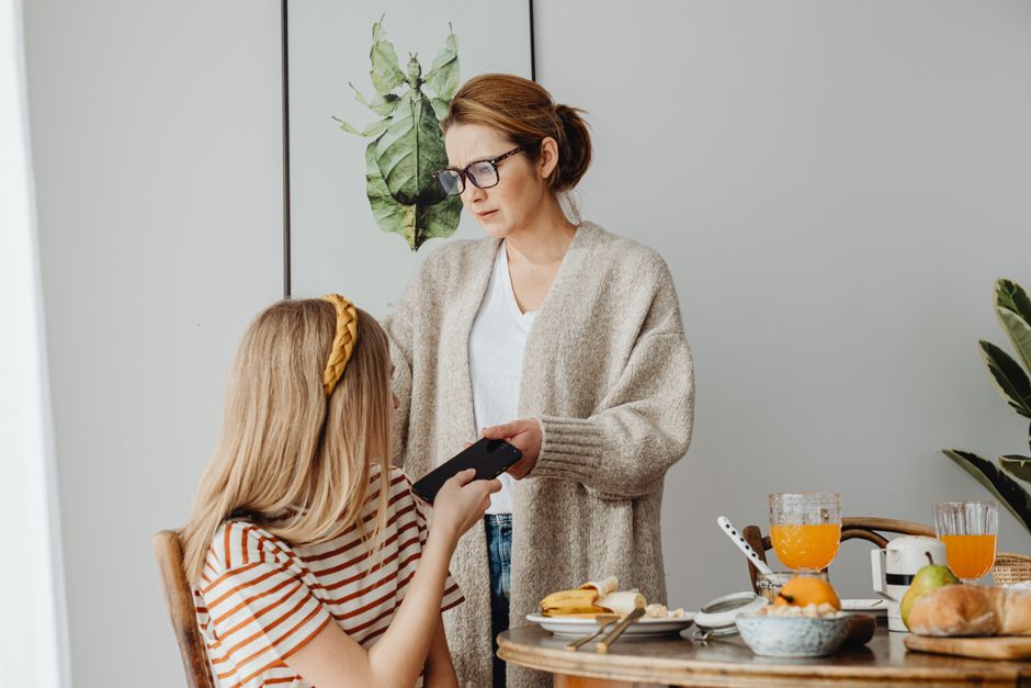 Photo by https://kaboompics.com/ on Pexels A mother correcting her teenage daughter's behavior during breakfast, conveying parenting dynamics. - Photo by https://kaboompics.com/ on Pexels