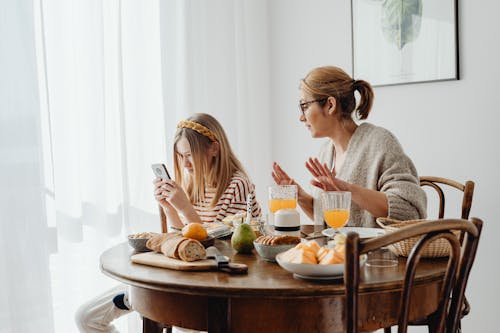 Free Mother Looks at her Daughter's Phone Stock Photo