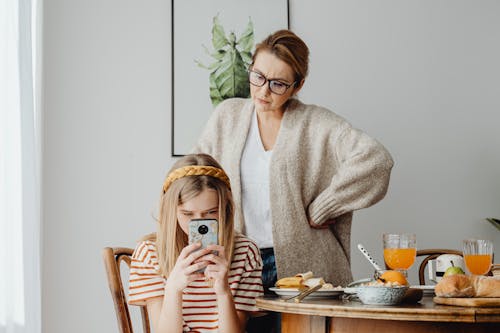 Woman Frustrated about Her Daughter Using Mobile Phone During Breakfast