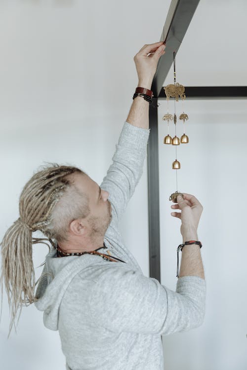 Free Man Hanging Decorative Charm on a Rail  Stock Photo