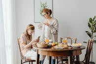 Daughter Using Phone in front of Wooden Table