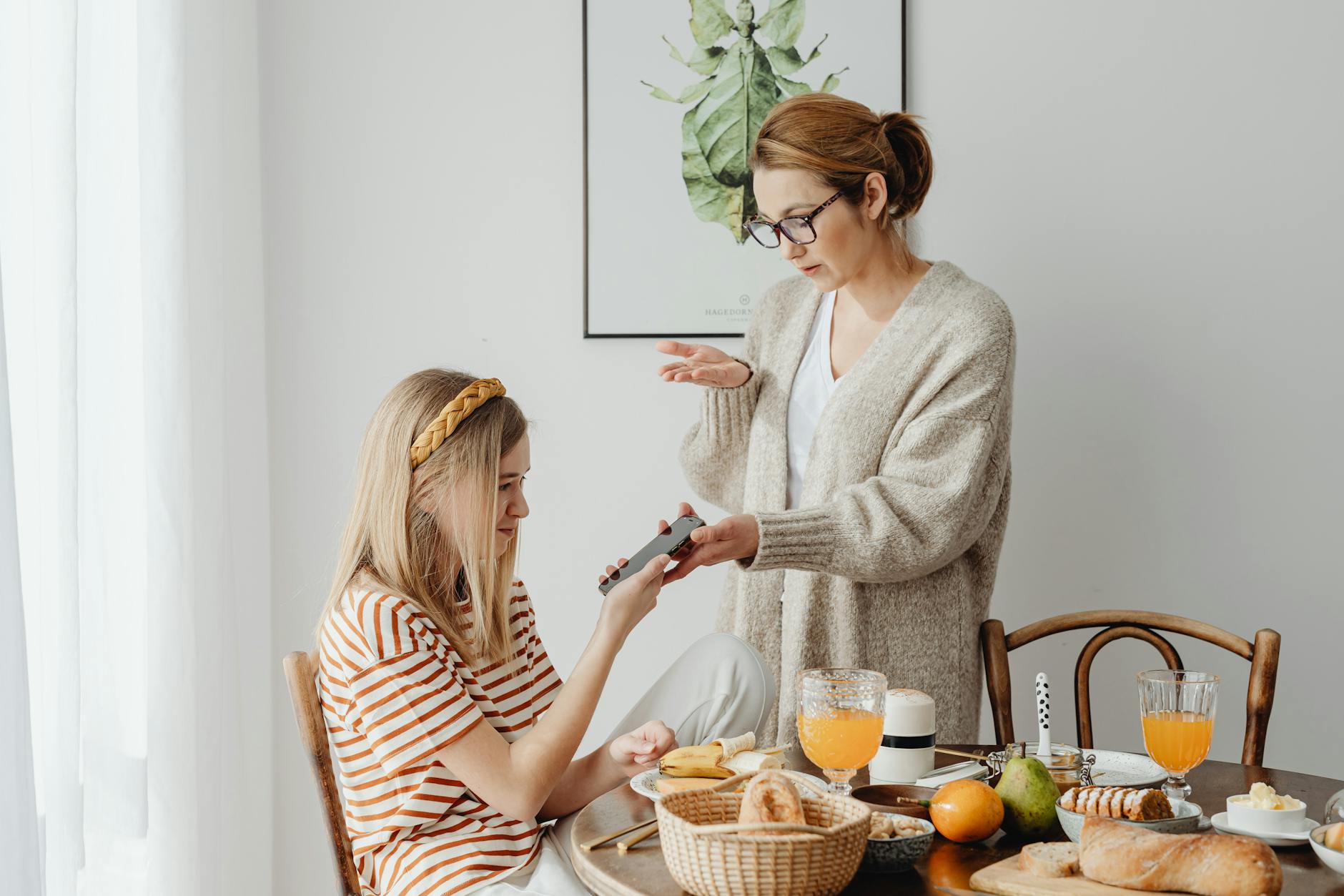 My Teenager Is Out of Control — What Can I Do Right Now? - A mother and daughter in a discussion over phone use during bre...