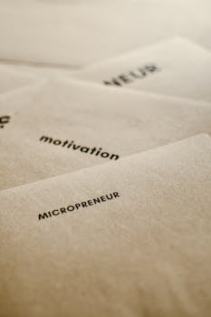Vertical shot of textured papers with printed motivational words like 'micropreneur.'