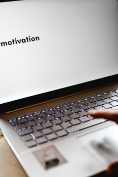 Close-up of a laptop with 'motivation' on screen, highlighting productivity and inspiration.