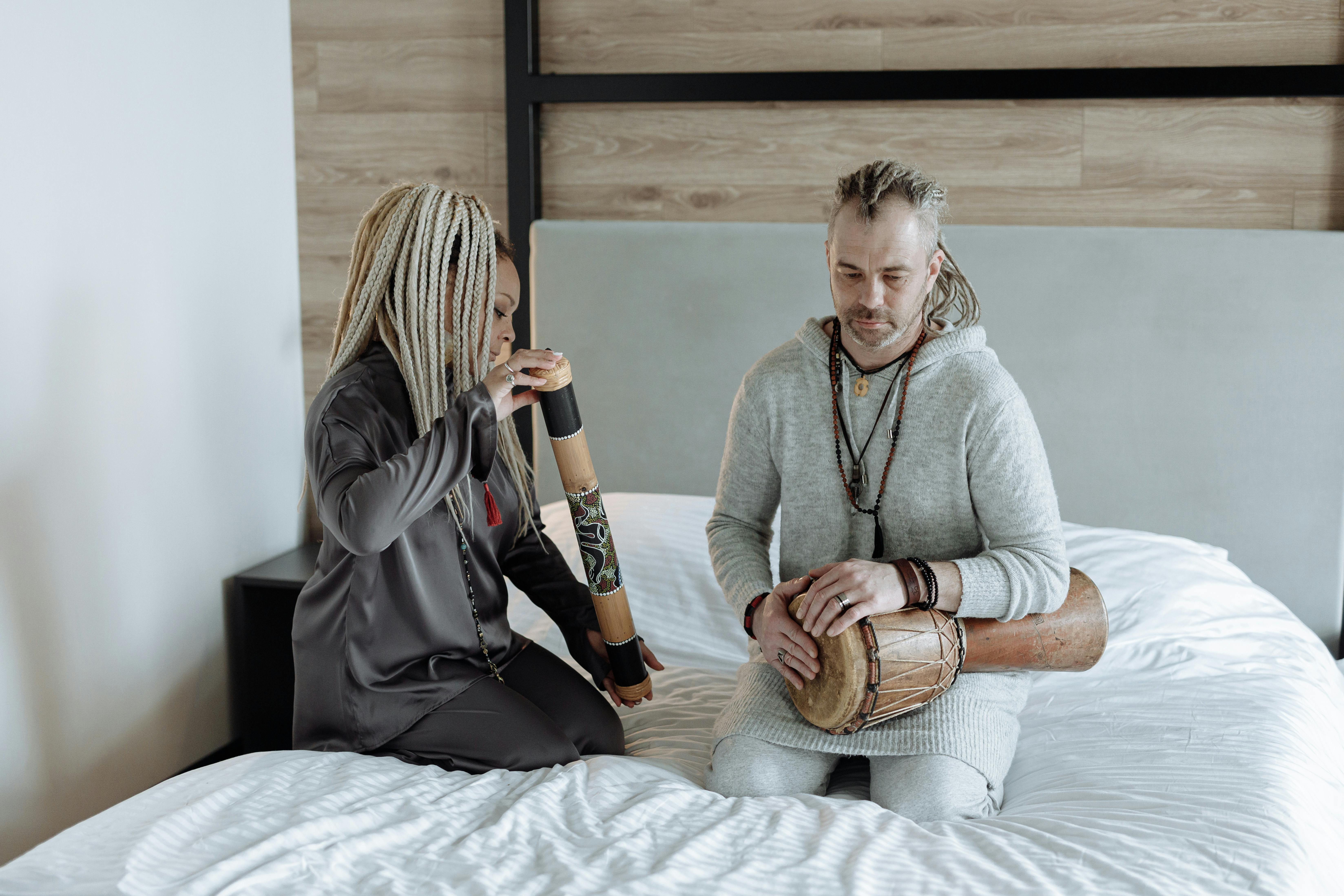 Free Woman in Gray Zip Up Hoodie Sitting on Bed Stock Photo