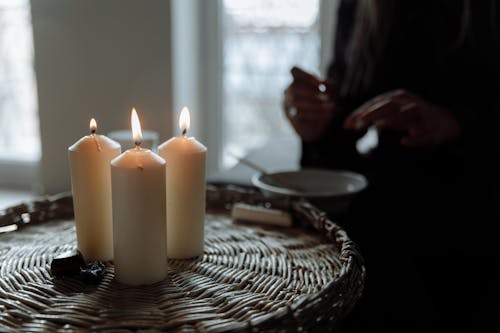 White Pillar Candles on Brown Woven Basket