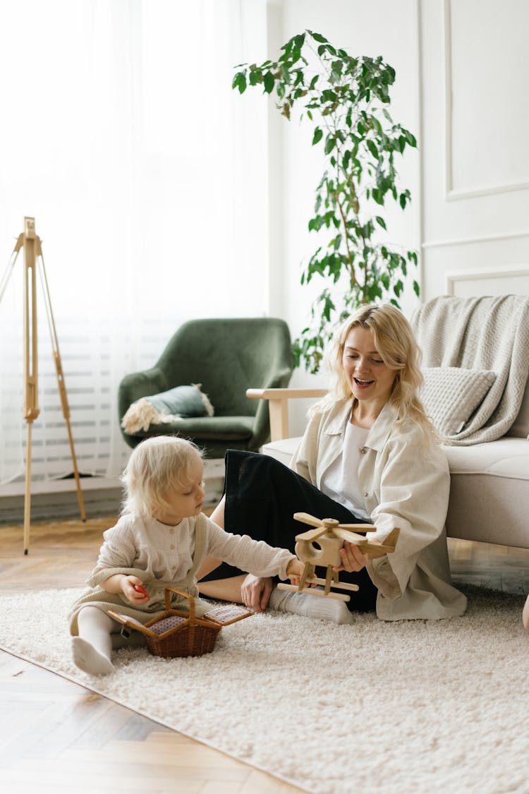 Woman And A Toddler Sitting On A Rug