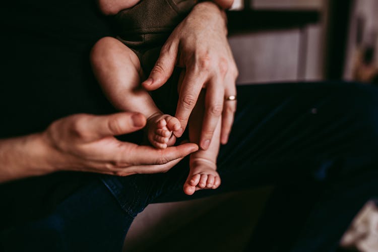 Crop Parent Touching Feet Of Unrecognizable Baby