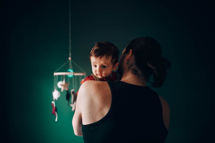 Unrecognizable Man With Baby In Arms