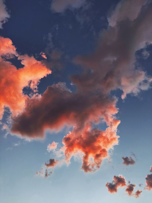 Free Peaceful fluffy orange clouds covering bright sunny blue sky in daytime in summer Stock Photo