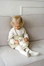 Girl in Beige Sweater Holding White Short Coated Dog on Gray Couch