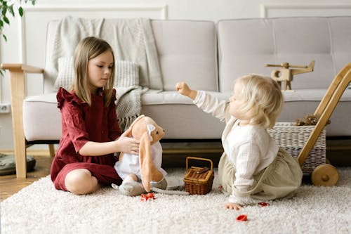 Children Sitting on Carpet While Playing