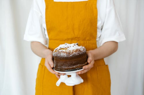 Close-Up Shot of a Person Holding a Chocolate Cake