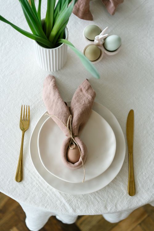 Free A beautifully arranged Easter table with elegant cutlery and pastel-colored eggs. Stock Photo