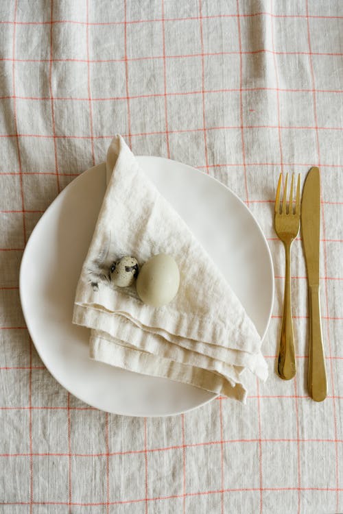 White Ceramic Plate With Eggs On Table Napkin