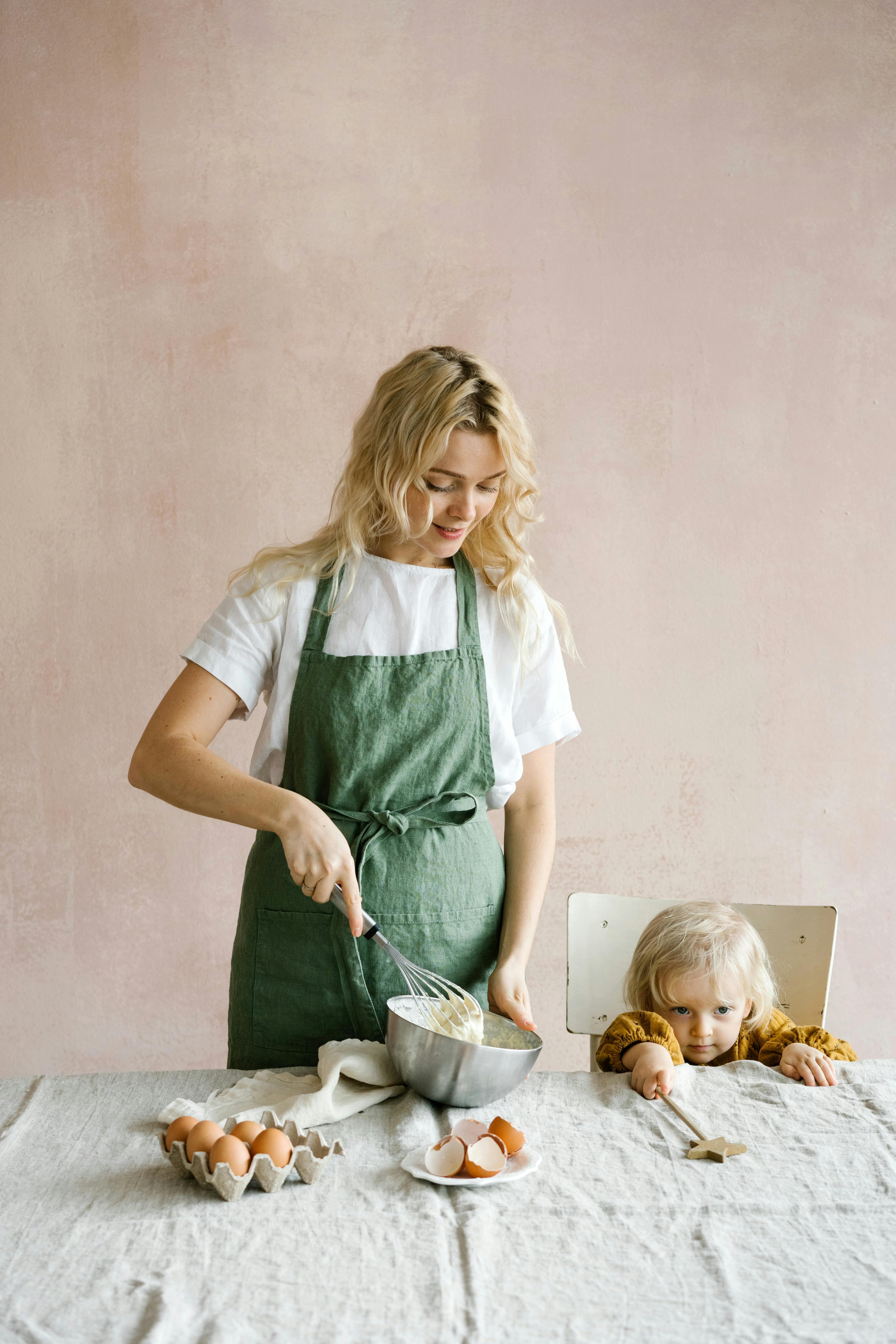 a woman baking beside her daughter