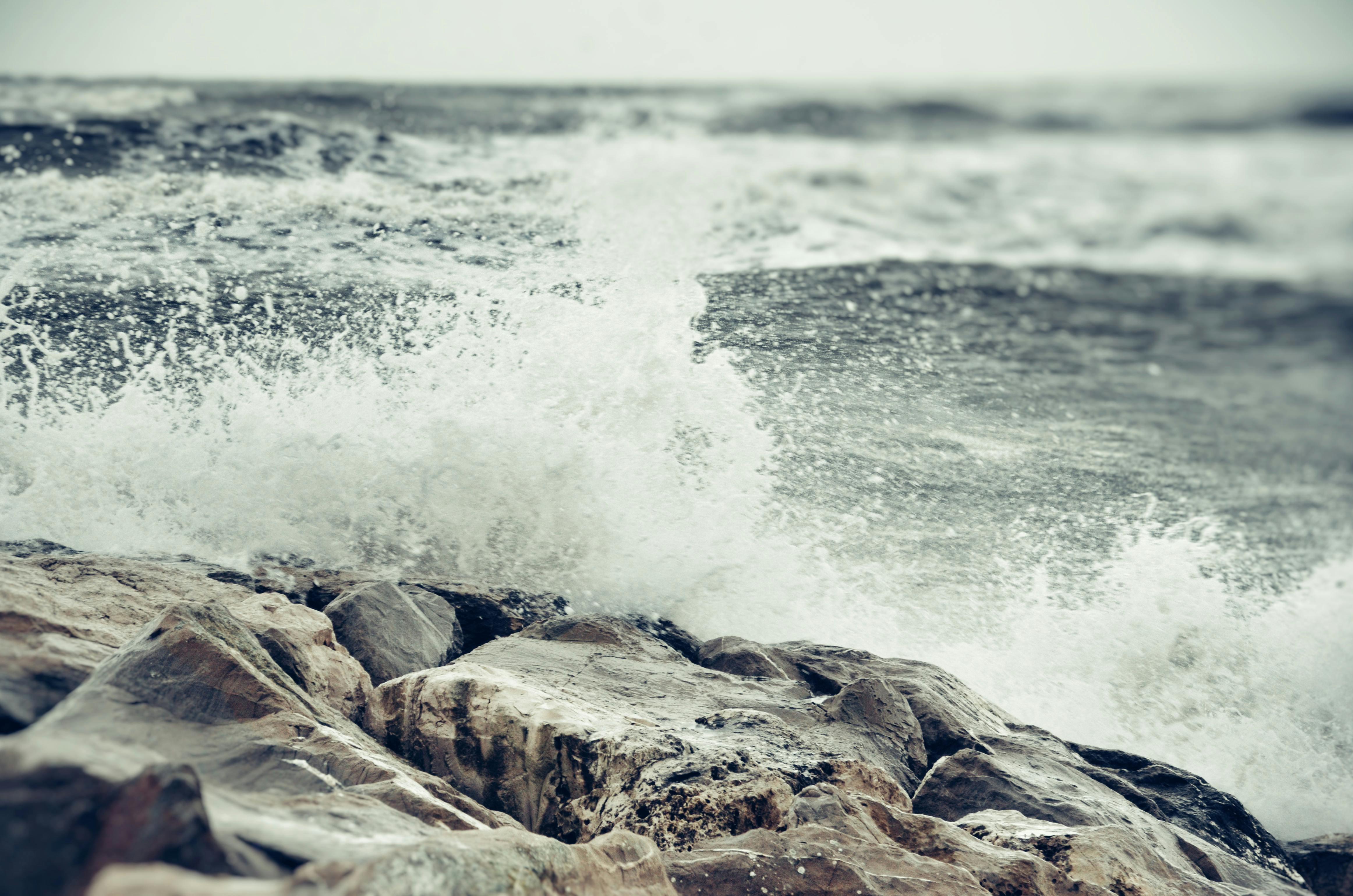 rough sea with waves breaking against rocky coastline