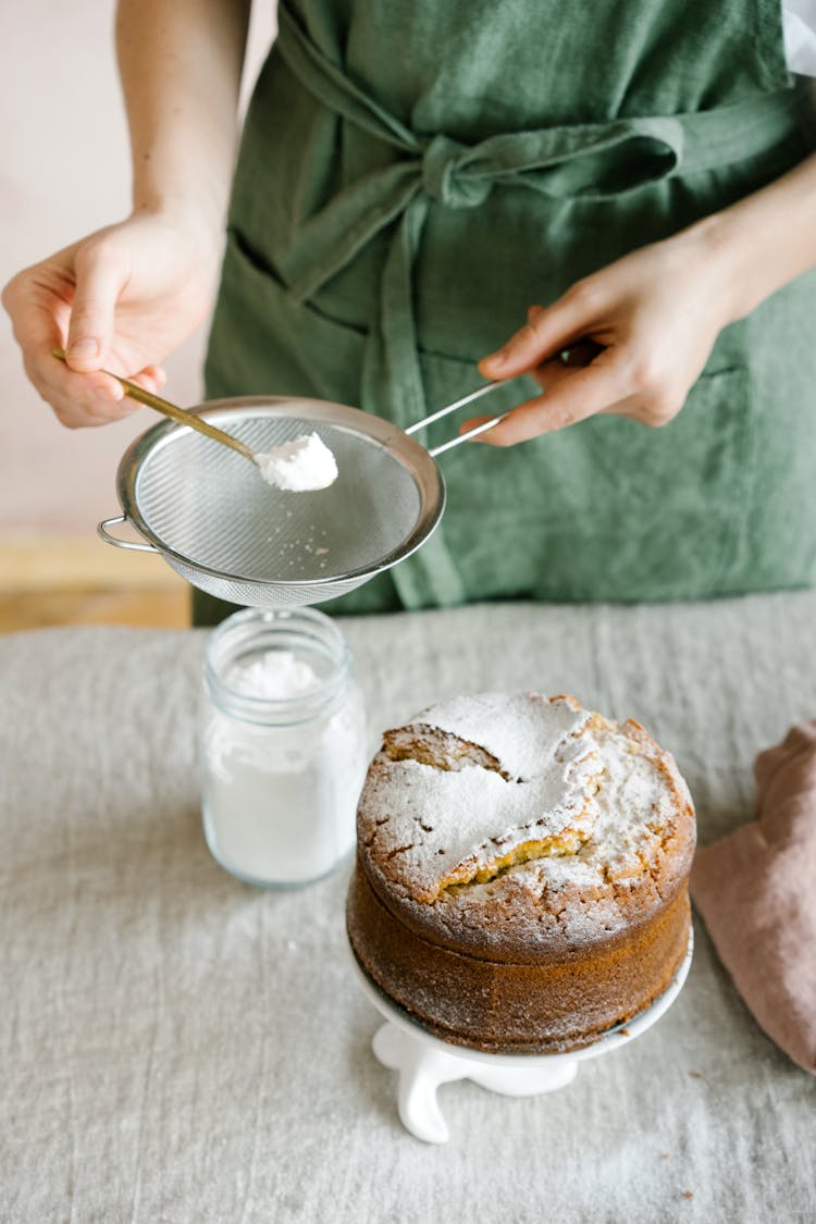 A Woman Sifting A Flour