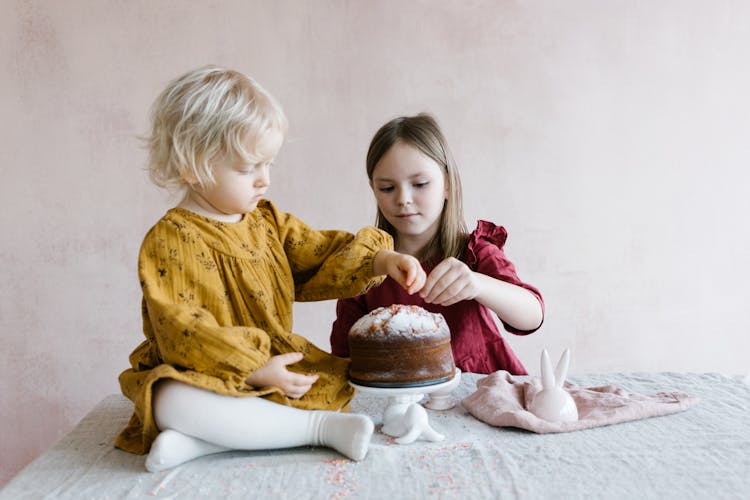 Young Girls Decorating The Cake