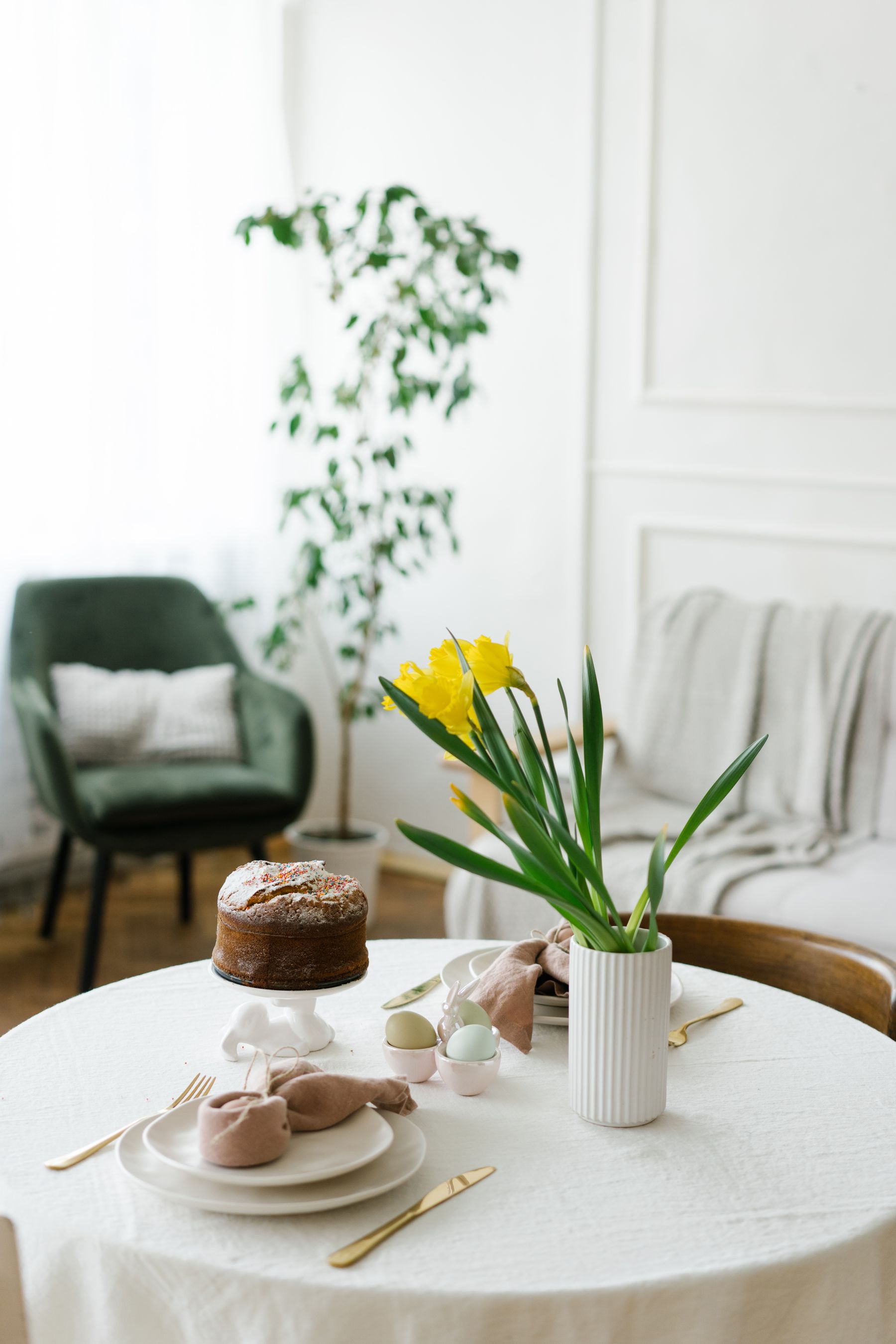 Bright living room with an Easter table, spring flowers and restrained seasonal decorations