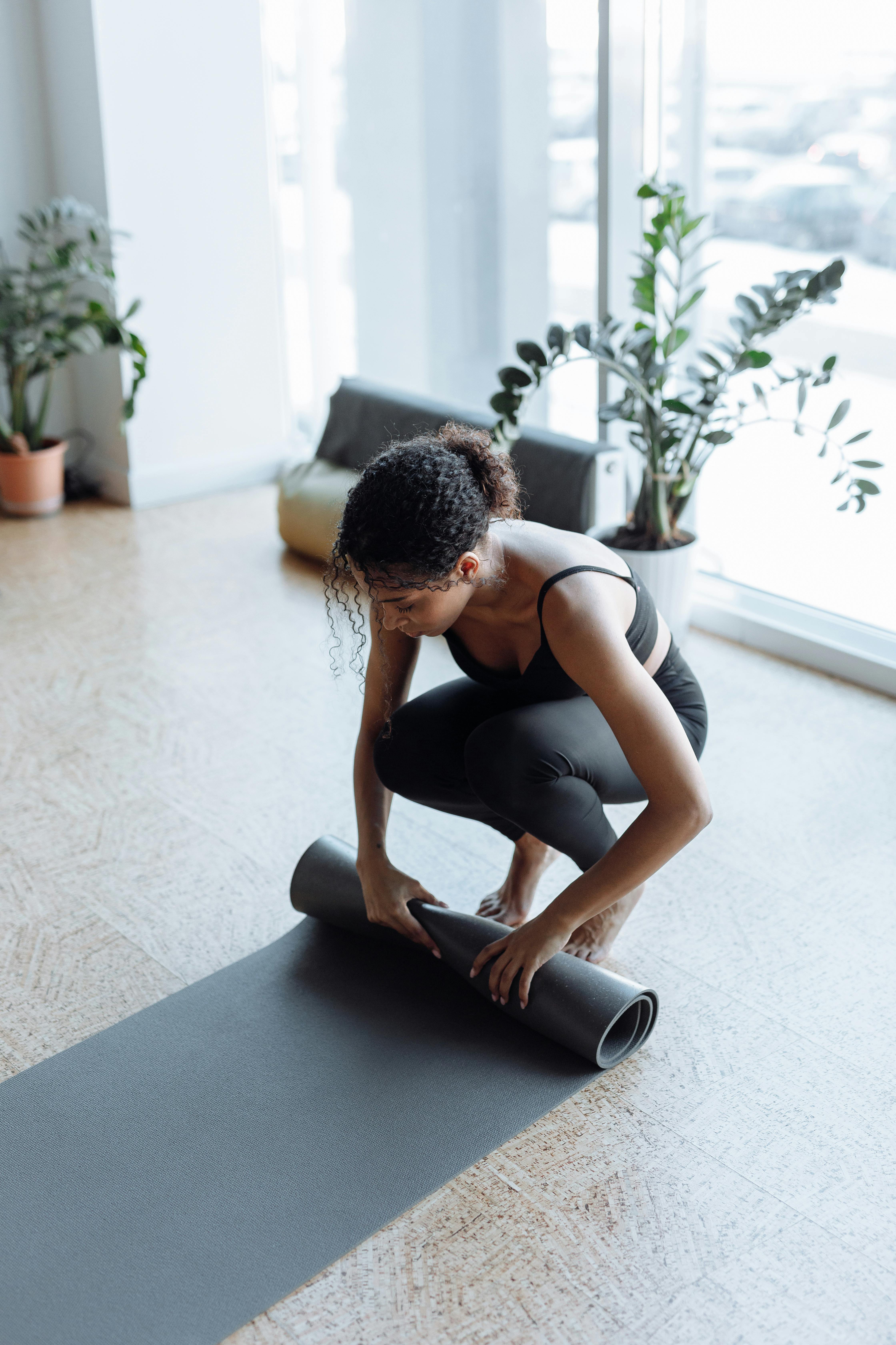 a woman rolling a yoga mat