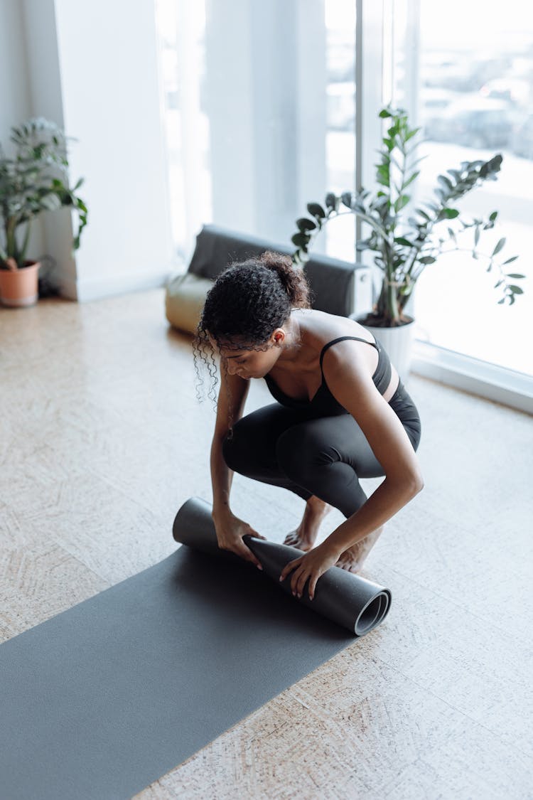 A Woman Rolling A Yoga Mat 