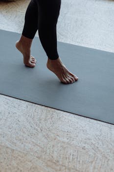 Close-up of legs on a yoga mat, perfect for fitness and wellness visuals.
