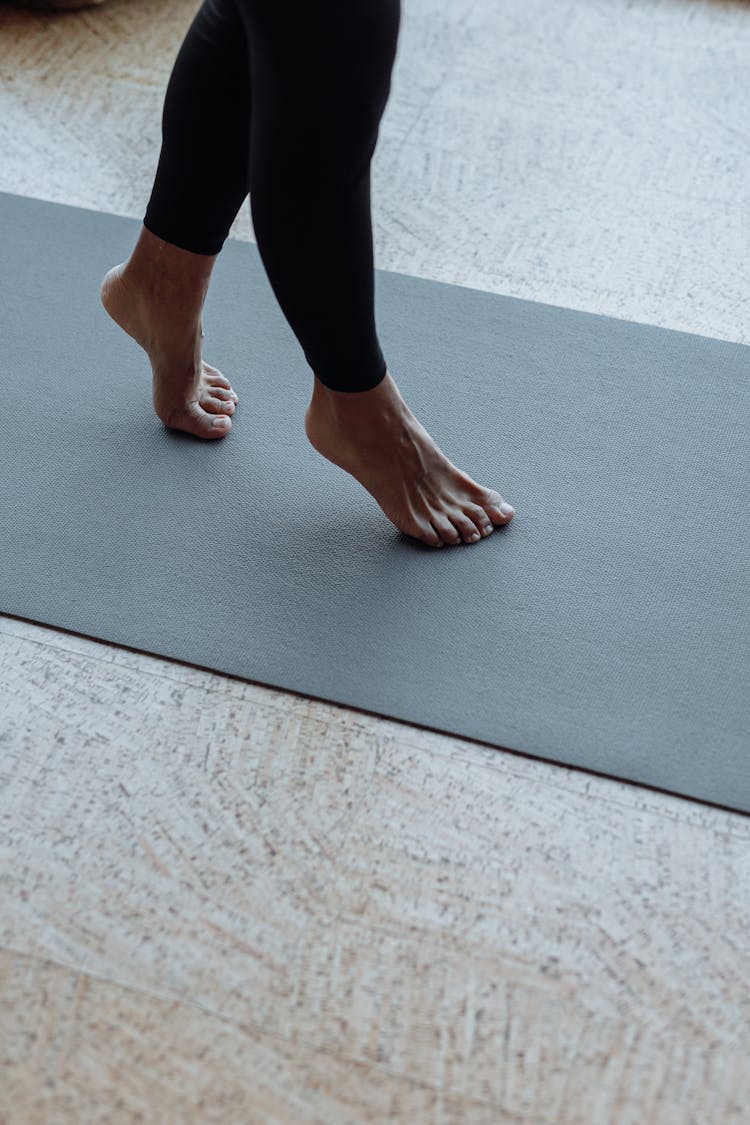 A Person Stepping On A Yoga Mat 