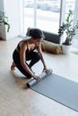 Woman in Black Tank Top and Gray Leggings Doing Yoga on Gray Yoga Mat