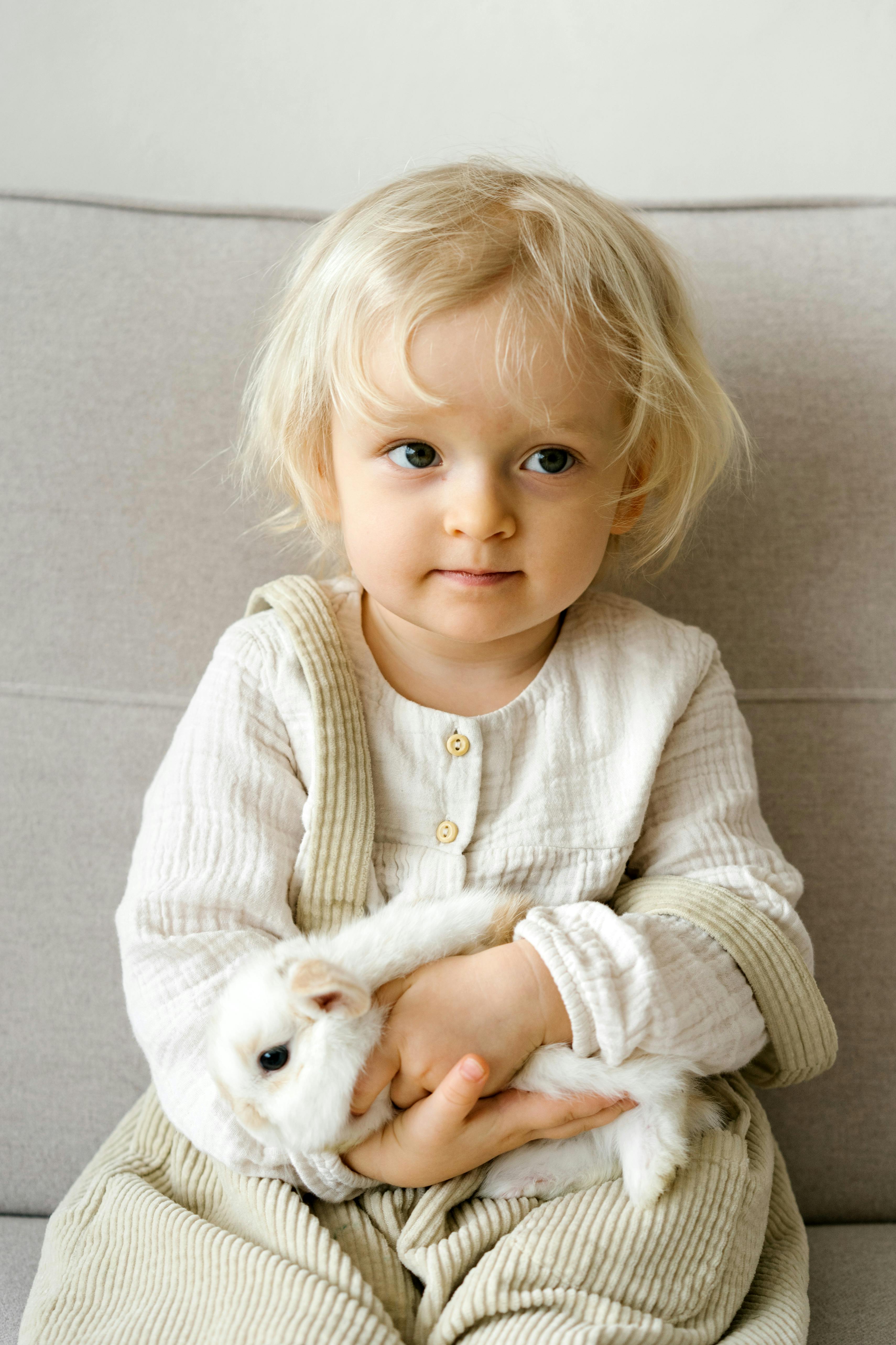 a cute girl holding a white rabbit