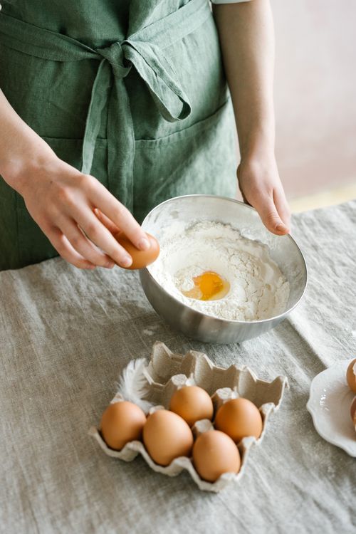 Free Close-up of hands preparing dough with fresh eggs, perfect for homemade baking enthusiasts. Stock Photo