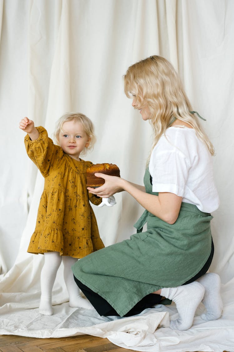 Mother And Daughter Holding A Cake