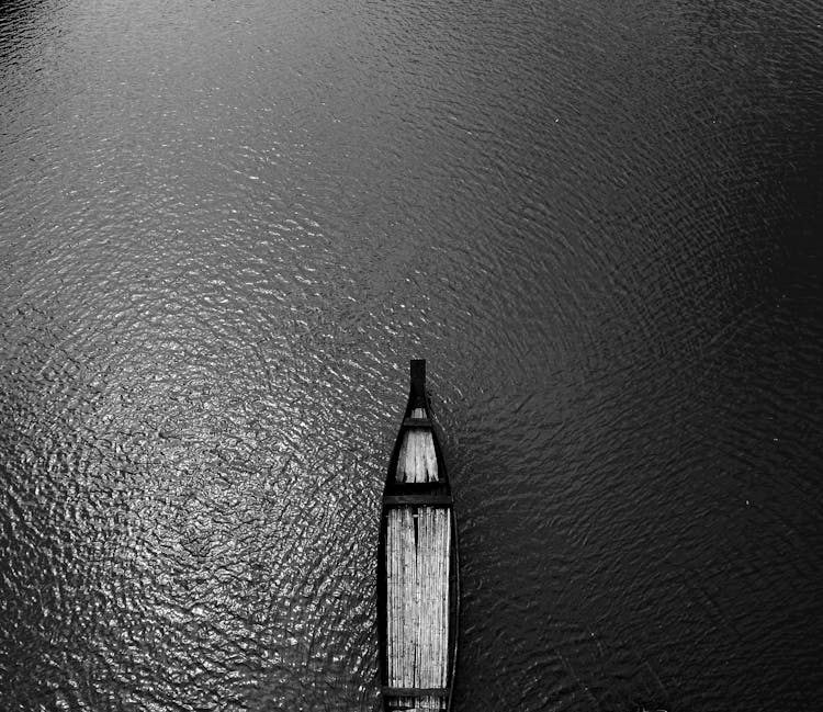 Aerial View Black Wooden Row Boat On Body Of Water