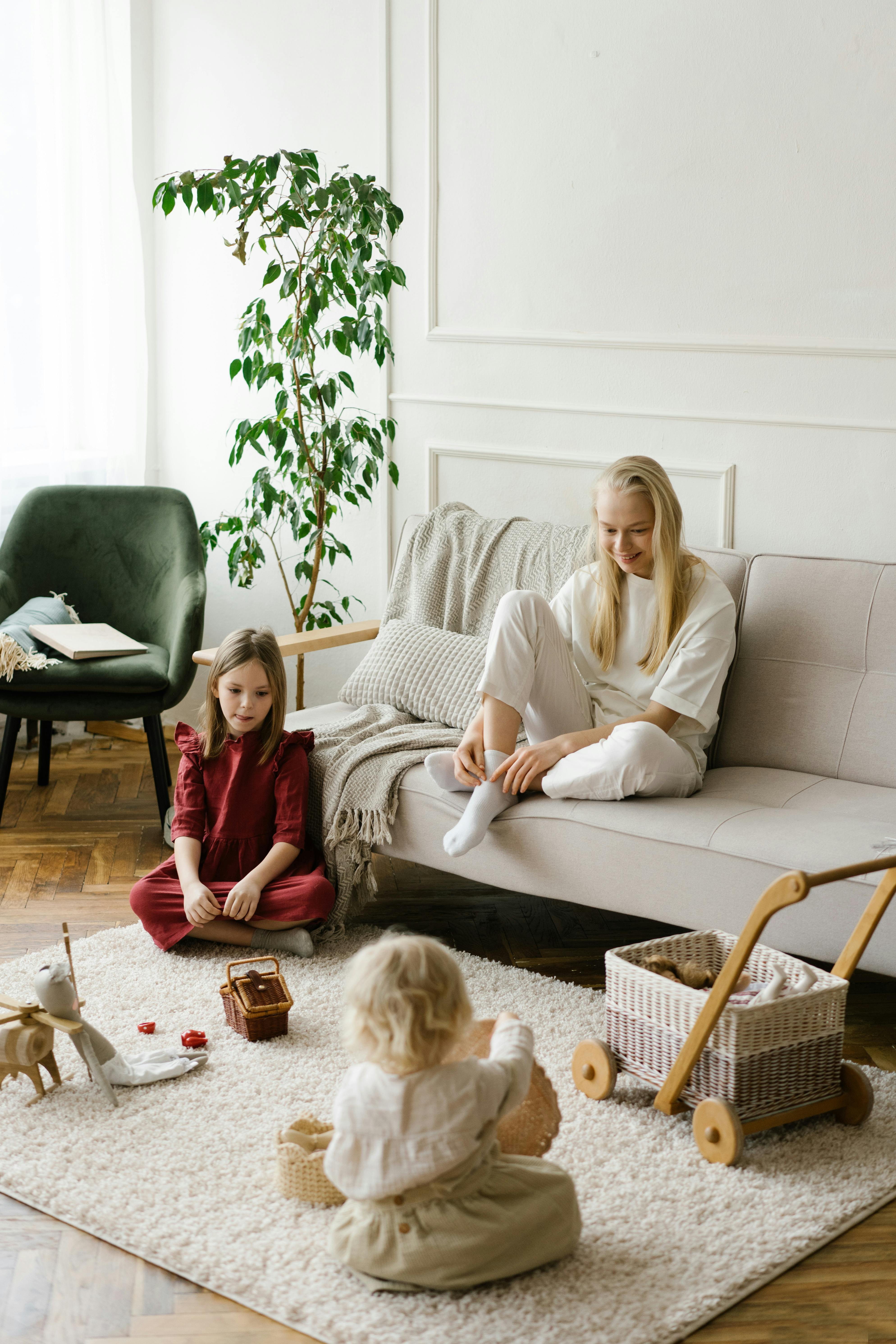 mother watching children playing with toys on soft carpet