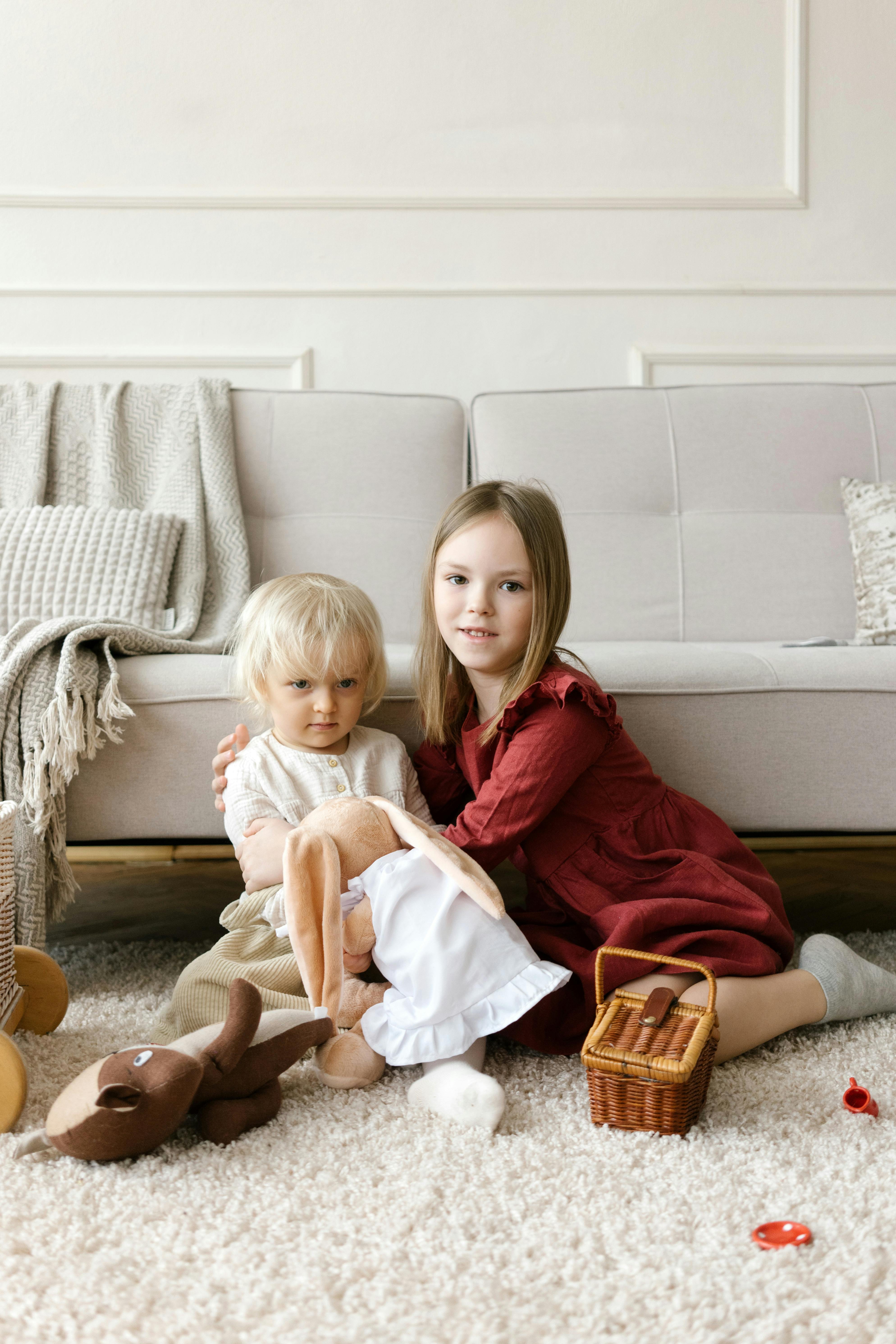 little girls sitting on floor and playing with toy