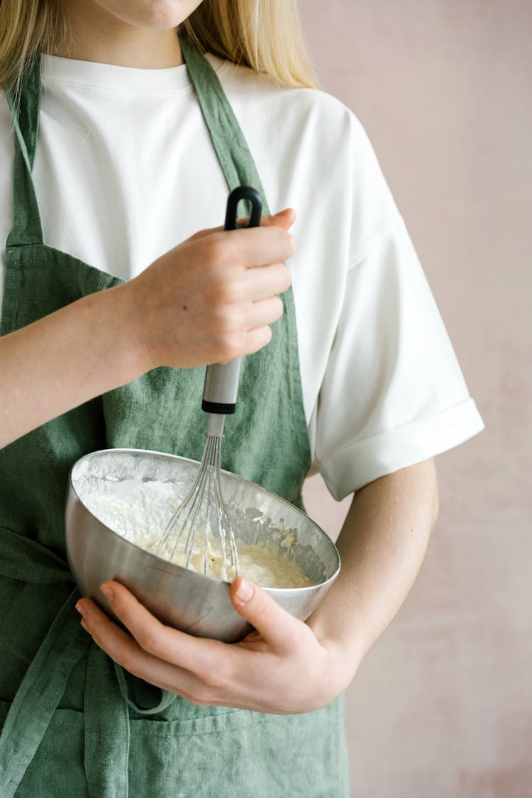 Female Mixing Ingredients In Bowl With Whisk