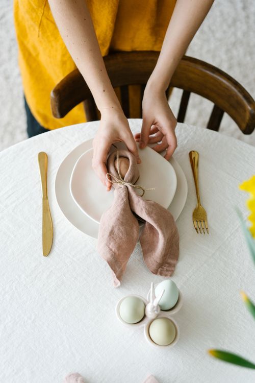 Free From above of crop unrecognizable female serving table with eggs during Easter in daylight Stock Photo