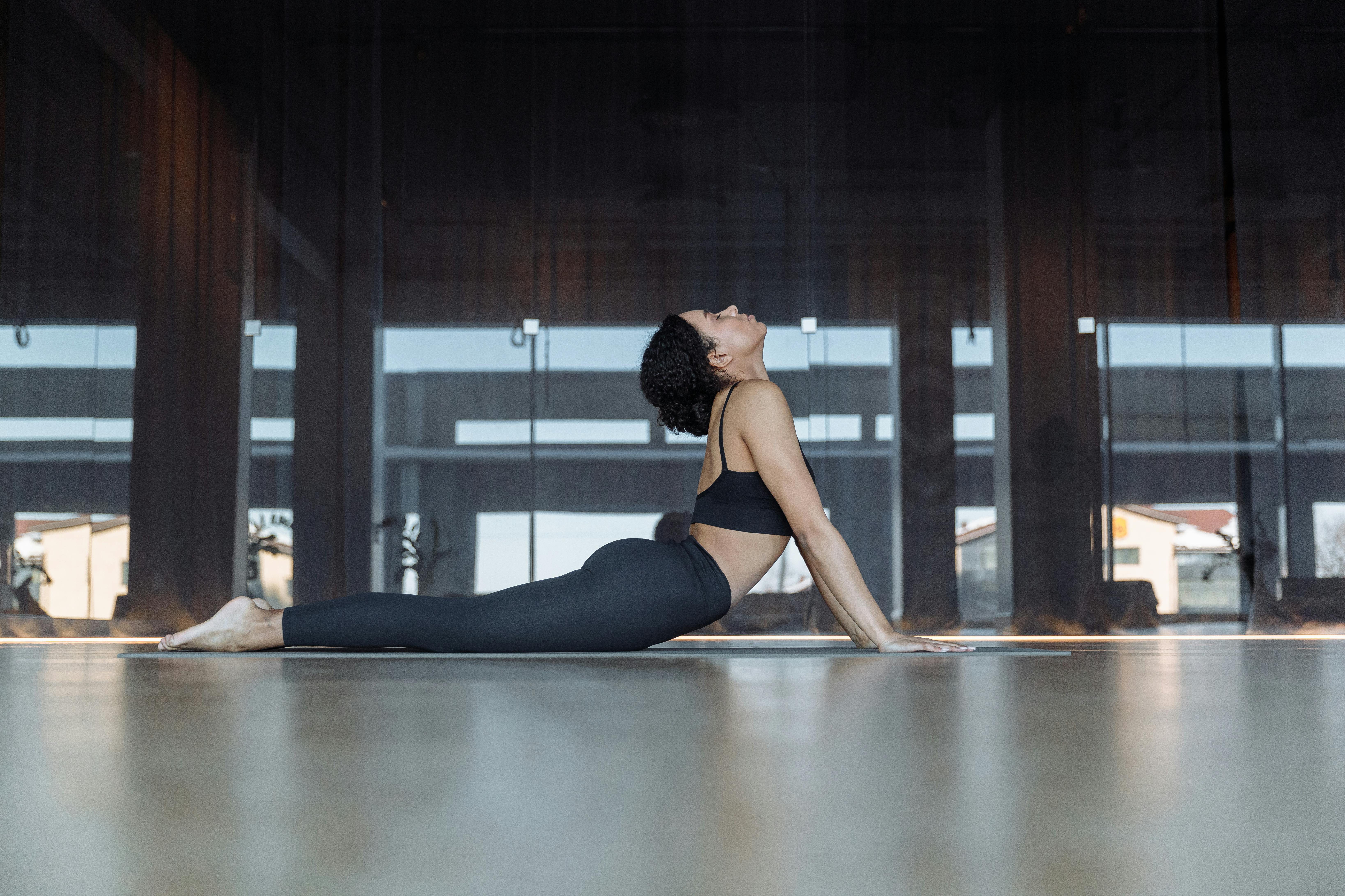 A focused woman performing yoga indoors, showcasing flexibility and concentration.