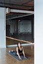 Woman in Black Crop Top and Leggings Stretching on Yoga Mat