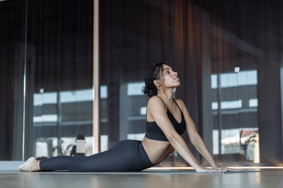 Apple Fitness+ vs Peloton Yoga: Beginner Value (2025) A young woman doing a yoga pose in a modern studio, promoting wellness and relaxation.