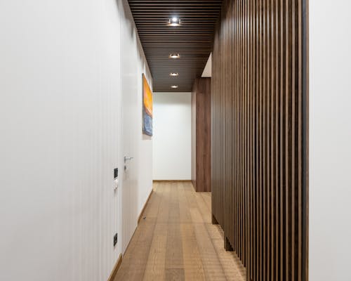 Free A sleek, contemporary hallway featuring wood paneling and modern lighting fixtures. Stock Photo