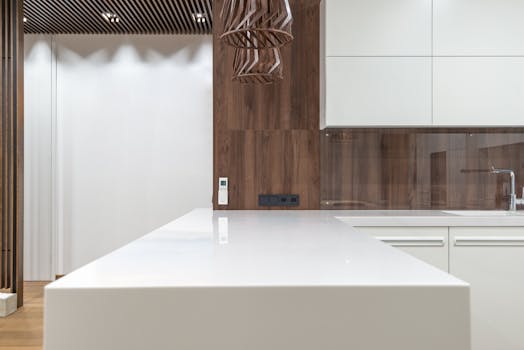 Sleek and contemporary kitchen with white countertops and wooden accents.