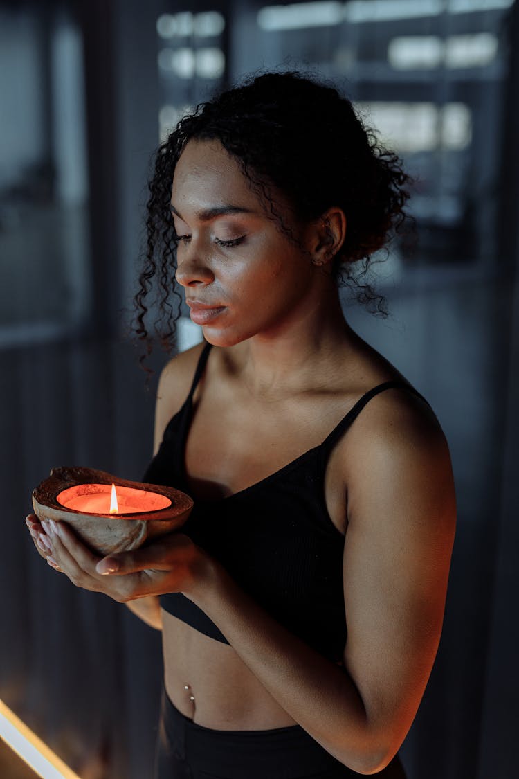 Woman In A Black Brassiere Holding A Lit Candle