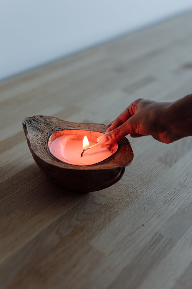 Close-Up Photo Of A Person's Hand Lighting A Candle
