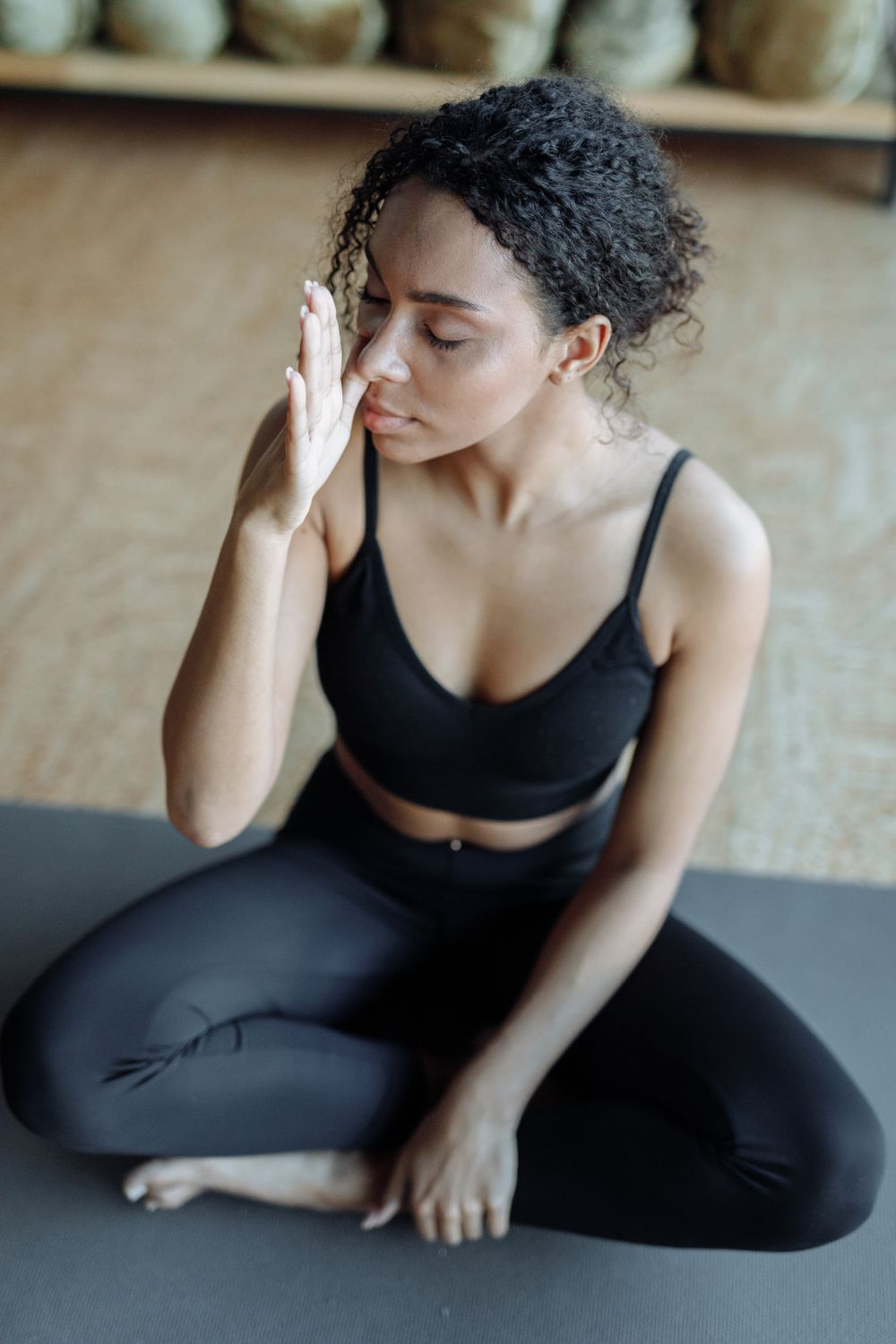 Woman in Black Active Wear Sitting on a Yoga Mat while Concentrating ...