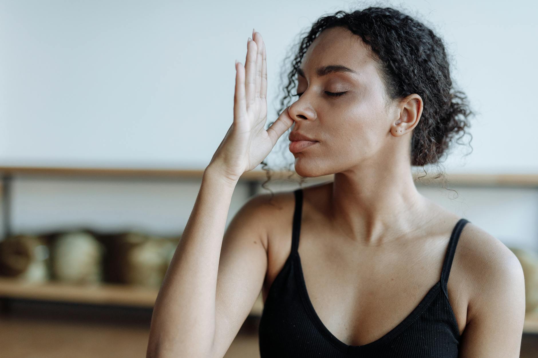 Close-up of a woman practicing yoga breathing techniques indoors, focusing on relaxation.