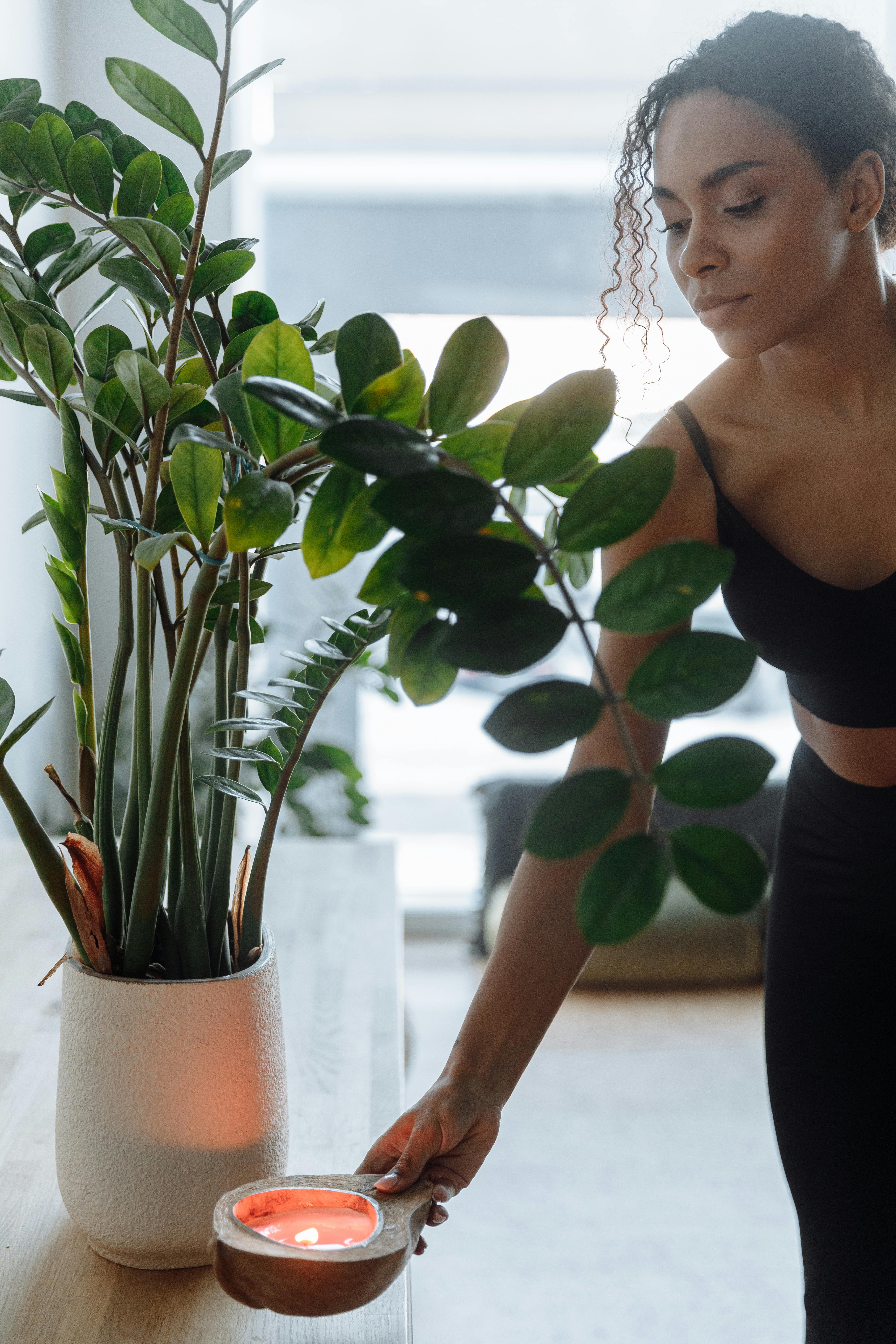 Woman in Black Tank Top and Black Leggings Standing Beside Green Plant