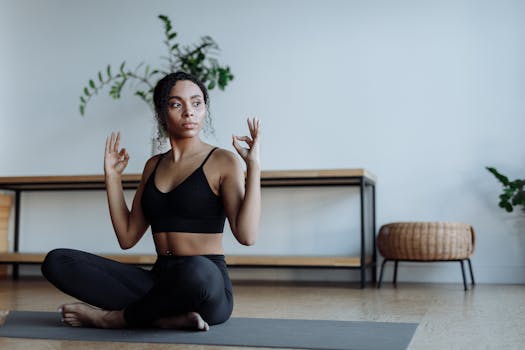 Woman practicing yoga in a modern studio, wearing a sports bra and leggings, promoting wellness.